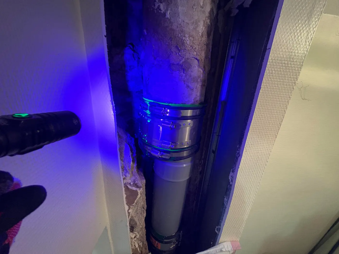 Traceur fluorescent révélé à la lampe UV sur une évacuation